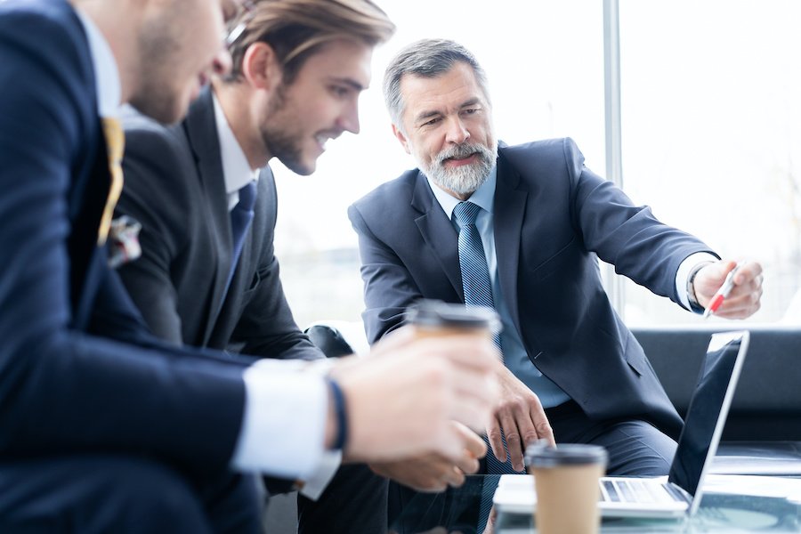 Group of business partners discussing ideas and planning work in office.